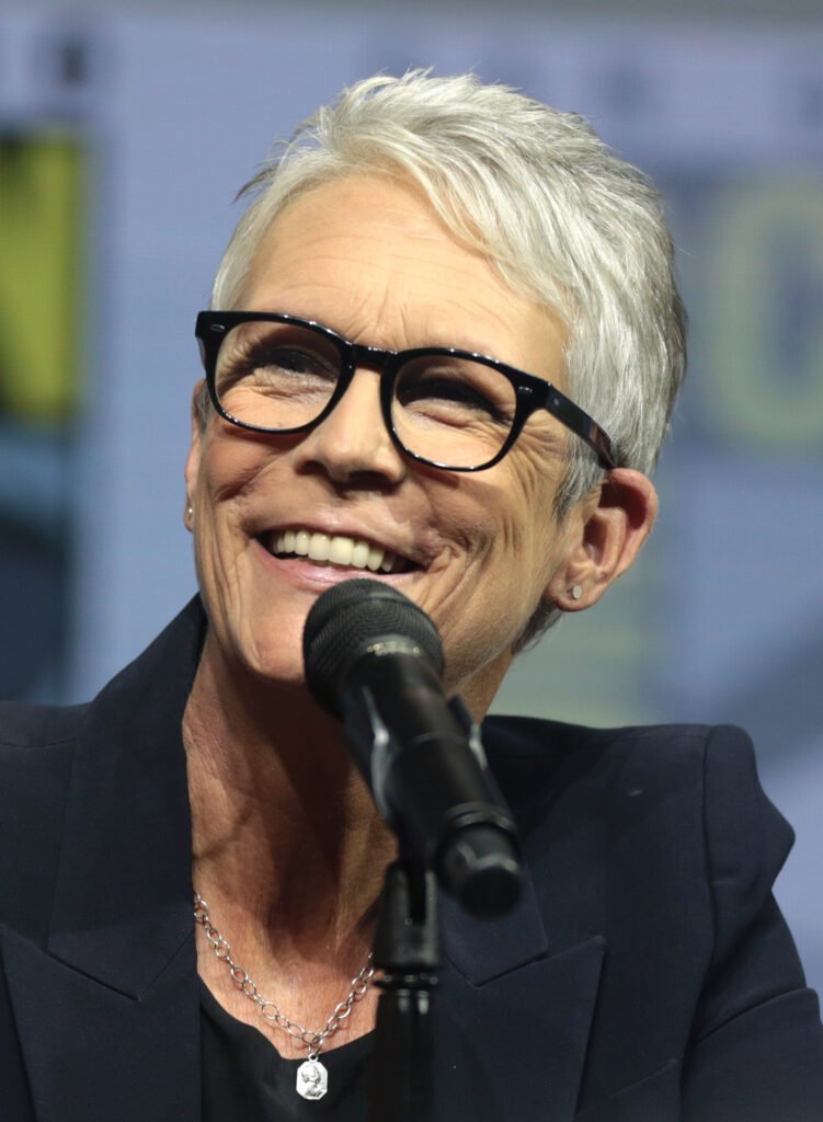 Jamie Lee Curtis speaking into a microphone at the 2018 San Diego Comic-Con Halloween panel